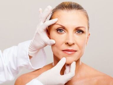 Le cosmétologue examine la peau du visage du patient